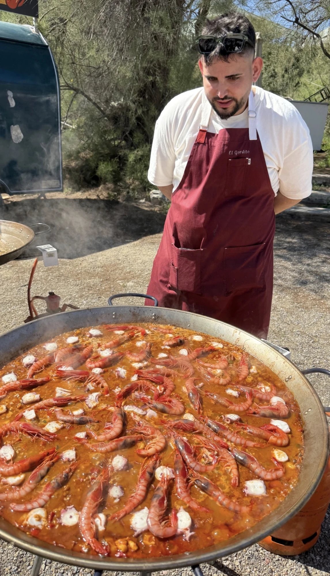 El Gordito delante de una paella de gamba roja y pulpo